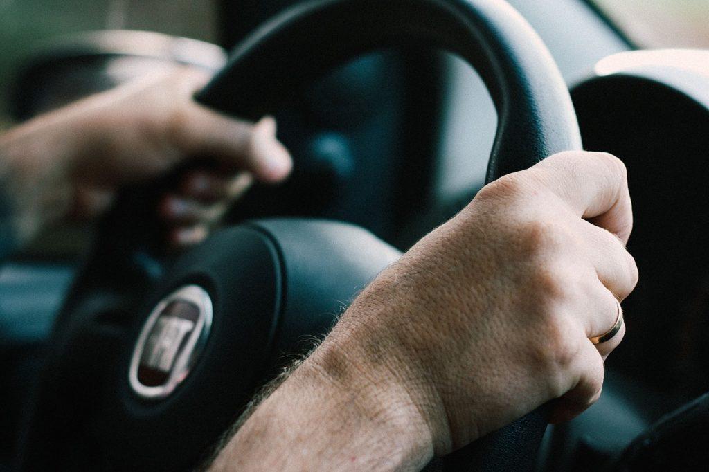 a person holding a steering wheel