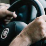 a person holding a steering wheel
