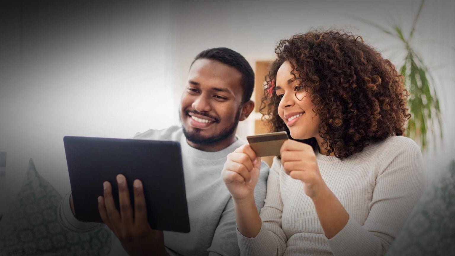 a man and woman looking at a tablet