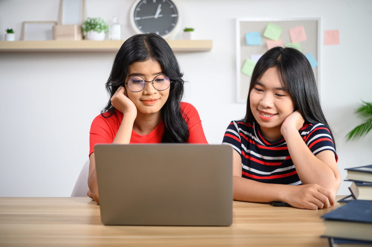 two young women working on a laptop